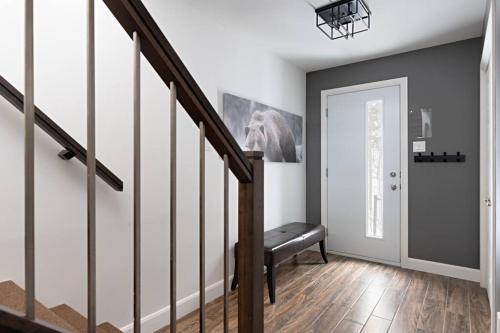 a hallway with a staircase with a bench next to a door at 20- Chalet à louer à Stoneham (CITQ287685) in Stoneham
