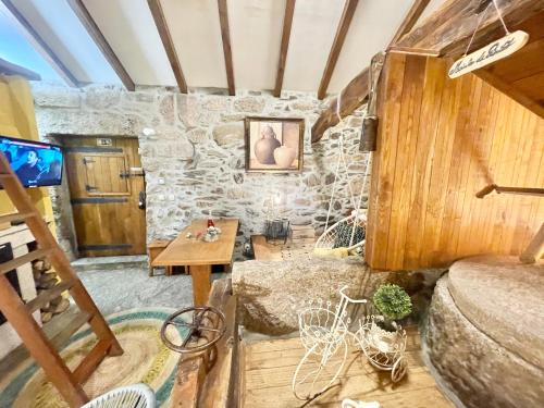 a room with a stone wall and a table at Moinho de Brião in Montalegre