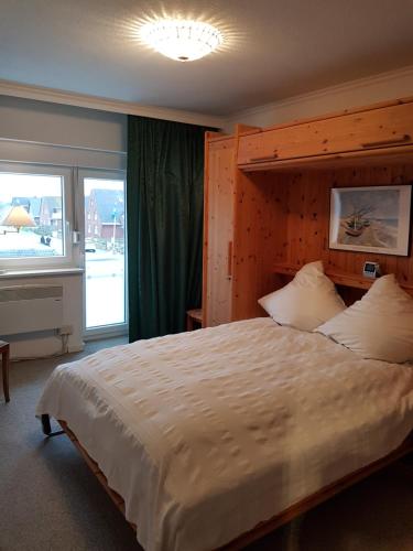 ein Schlafzimmer mit einem großen Bett und einem großen Fenster in der Unterkunft Seestern in Hörnum