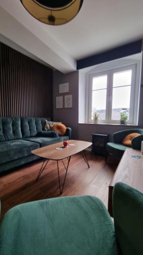 a living room with a couch and a coffee table at Apartament ZajkoSki in Duszniki Zdrój
