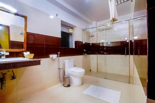 a bathroom with a toilet and a glass shower at THE FAME HOTEL in Jādabpur