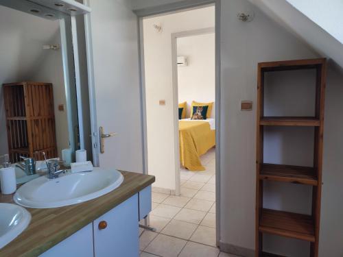 uma casa de banho com 2 lavatórios e um quarto em Charmante villa avec accès direct à la mer em Sainte-Rose