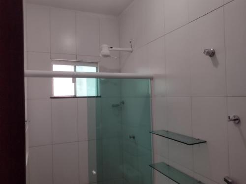 a bathroom with a glass shower with a window at Temporada Precisão Beta in Arraial do Cabo