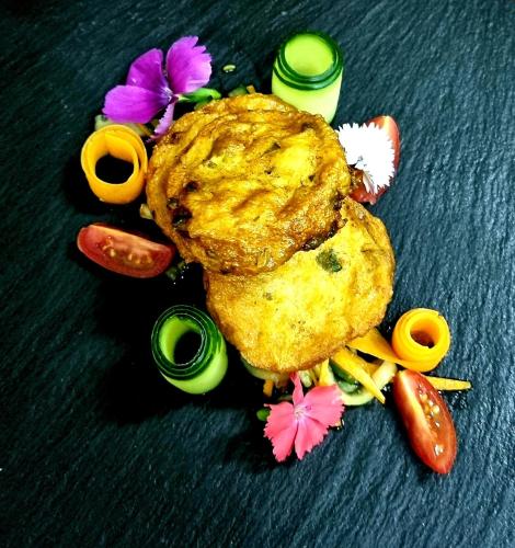a plate of food with some food and some flowers at The Zarafa in Hazyview
