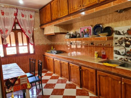 een keuken met houten kasten en een geruite vloer bij Appartements Dar Rahma in Chefchaouene