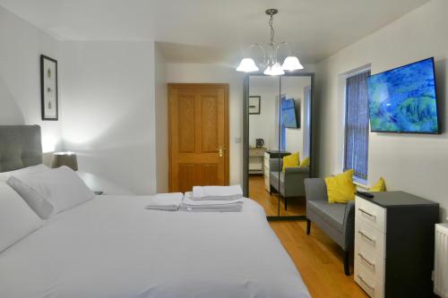 1 dormitorio con cama blanca y sofá en Marehay Hall Farm en Belper