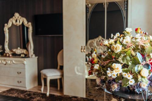 a room with a table with a bouquet of flowers at Perfect Sleep - luxurious apartment near trade fair in Kielce