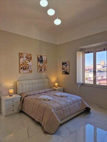 1 dormitorio con 1 cama grande y 2 mesitas de noche en L'Elisir Home en Caserta