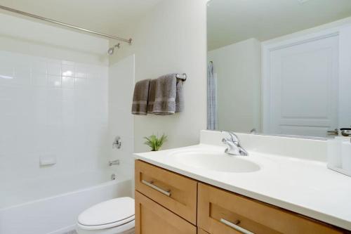 a white bathroom with a sink and a toilet at Condo with Gym and Pool in Pentagon City 8min to DCA in Arlington