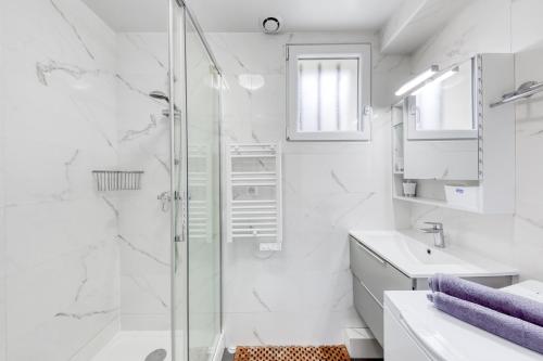 een witte badkamer met een douche en een wastafel bij Silver&Gold House Pro & Family in Ivry-sur-Seine