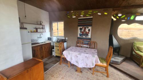 eine Küche mit einem Tisch, einem Tisch und Stühlen in der Unterkunft Casita entre dunas al son del mar in Salinas
