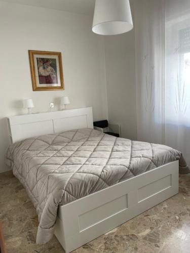 een wit bed in een witte slaapkamer met een witte muur bij Casa Simo Apartment in Castel di Sangro