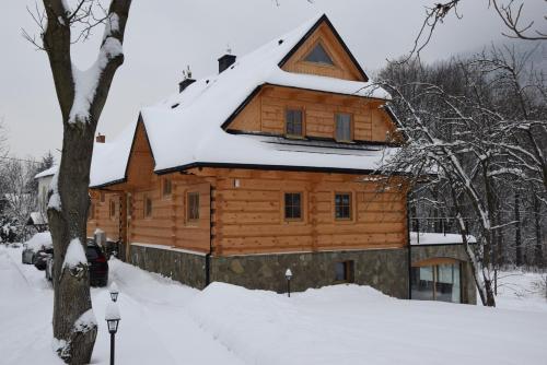 a log cabin with snow on top of it at Willa Góralka in Szczyrk