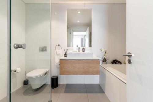 a bathroom with a toilet and a sink and a mirror at The Solis in Cape Town