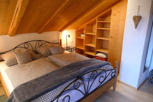 1 dormitorio con 1 cama en una habitación con techos de madera en Ferienwohnung Goller en Lenggries