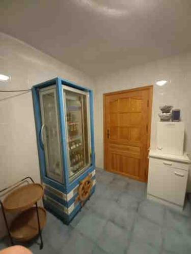 a room with a blue cabinet and a refrigerator at Haus Kathrin in Zecherin