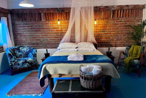 1 dormitorio con cama y pared de ladrillo en Casa Xochitl, en La Paz