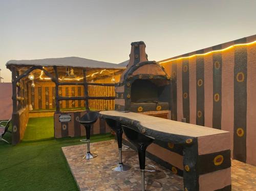 a play house with a table and an outdoor oven at alreaambreather2 in Sayq