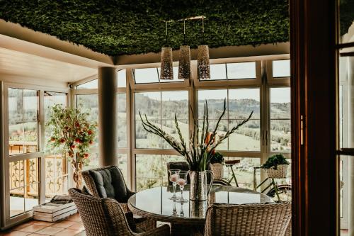 a dining room with a table and chairs and windows at Karolowy Dwór in Wisła