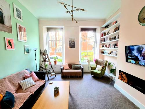 a living room with a couch and a table at Unique Victorian Home in Glasgow in Glasgow