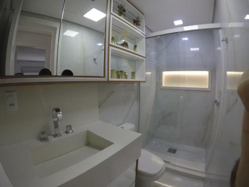 y baño blanco con ducha y aseo. en Apartamento encantador - perto PUCRS e perimetral, en Porto Alegre
