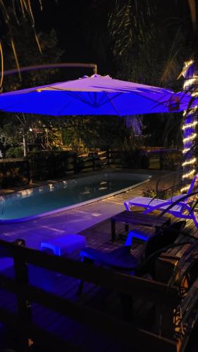 a blue umbrella over a swimming pool at night at Cabañas Pulmahue in Colón