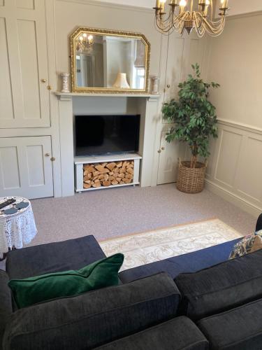 a living room with a couch and a mirror at Rosedene Regency Annex in Minster