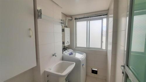 フロリアノポリスにあるApartamento Alto Padrão - Vista Panorâmicaのバスルーム(洗面台、トイレ付)、窓が備わります。