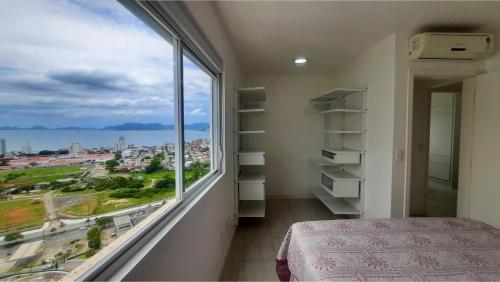 フロリアノポリスにあるApartamento Alto Padrão - Vista Panorâmicaのベッドルーム1室(市街の景色を望む大きな窓付)