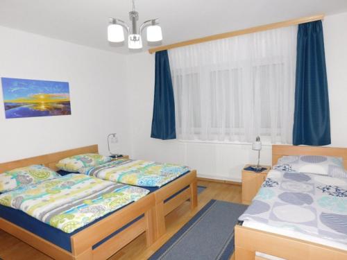 a bedroom with two beds and a window at Apartman Braja in Virovitica