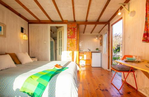 ein Schlafzimmer mit einem Bett und einem Schreibtisch sowie eine Küche in der Unterkunft Romantic Beach Cabin - Playa El Palmar in El Palmar