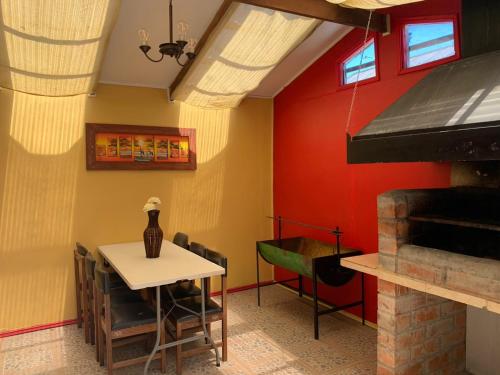 a dining room with a table and a red wall at Casa de la Ribera Pelantaro in Valdivia