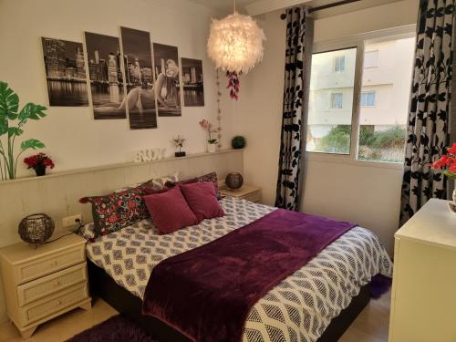 1 dormitorio con cama y lámpara de araña en FIRST Beach line, en Marbella