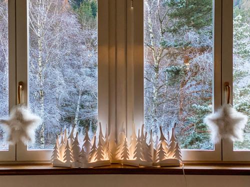 una ventana con una vela de Navidad delante de ella en Le Mansarde di Siberia, en Craveggia