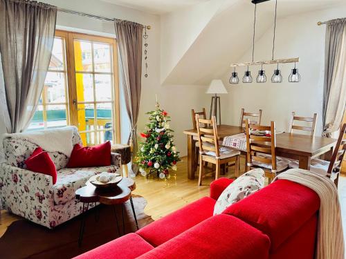 salon z czerwoną kanapą i choinką świąteczną w obiekcie Alpenliebe w mieście Bad Kleinkirchheim