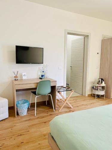 1 dormitorio con escritorio, ordenador y cama en Cale Verde, en Cagli