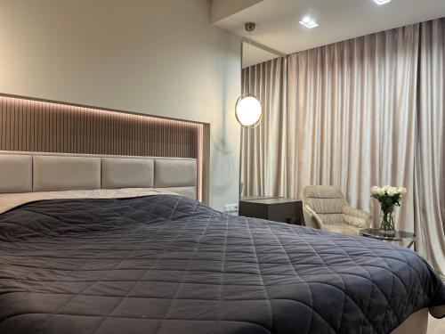 - une chambre avec un grand lit et une chaise dans l'établissement Oasis Luxury Apartments, à Chişinău
