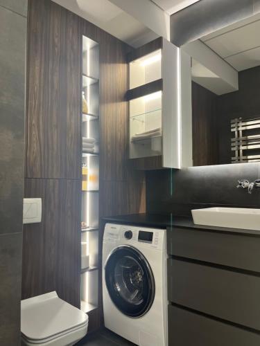 La salle de bains est pourvue d'un lave-linge et d'un sèche-linge. dans l'établissement Oasis Luxury Apartments, à Chişinău