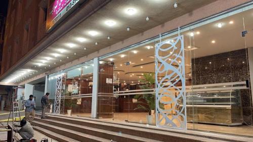 una tienda frente a un edificio con una gran ventana de cristal en شقق مساكن الراية المخدومه en Al Khobar