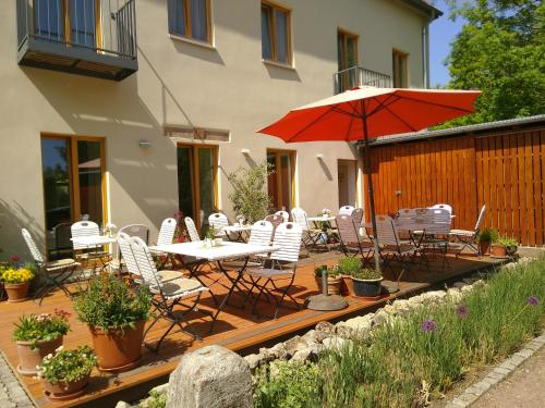 a patio with a table and chairs and an umbrella at Bio Hotel Kipperquelle in Weimar