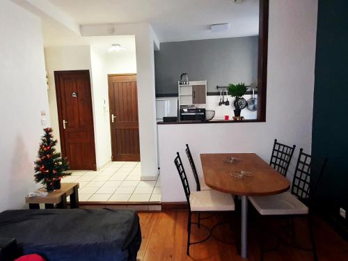 a living room with a table and a kitchen at La ruelle des 2 vallées in Arreau