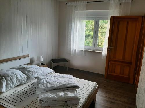 a white bedroom with a bed and a window at Ferienhaus Flotte Biene in Buggow in Rubkow