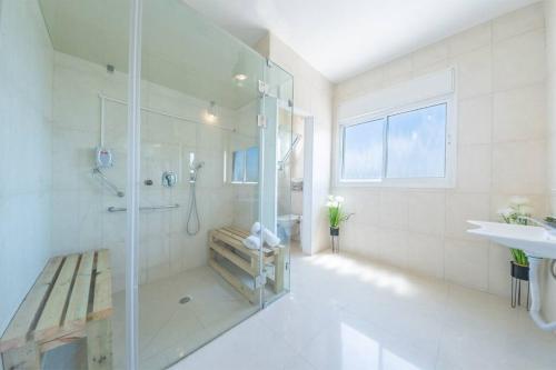 a white bathroom with a shower and a sink at אנדראה בוטיק - פנטהאוז מושלם עם בריכה פרטית וג'קוזי - Andrea Boutique Luxury Penthouse with heated pool and jacuzzi in Nahariyya