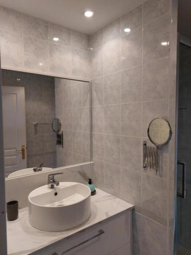 y baño con lavabo blanco y espejo. en Antibes T2 Vue mer 48m2 Terrasse Parking Piscine Plage en Antibes