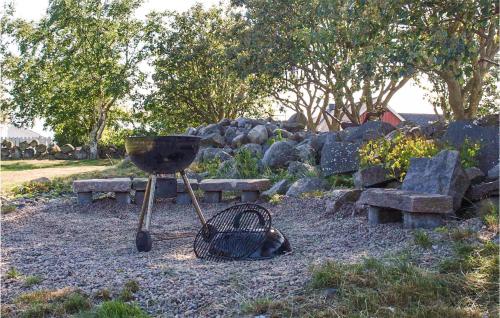 a grill with a basket and benches in a park at 1 Bedroom Lovely Home In Falkenberg in Falkenberg