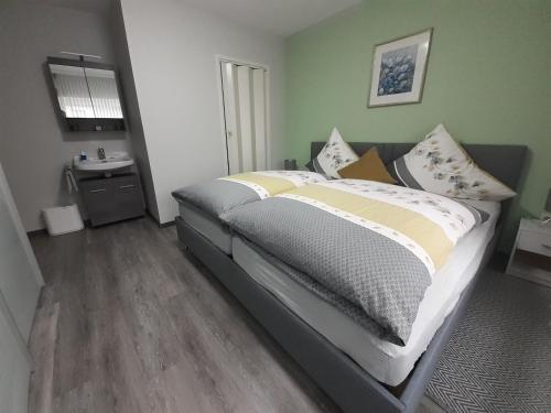 Un dormitorio con una cama grande con almohadas. en Nähe Nürburgring in Quiddelbach, Gästezimmer mit Lounge, en Quiddelbach
