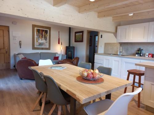 una cucina e una sala da pranzo con tavolo e sedie in legno di Chalet Relax a Pozza di Fassa