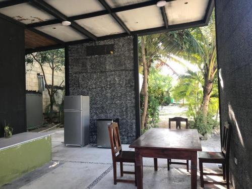 un patio con tavolo, sedie e frigorifero di Veleta Inn a Tulum