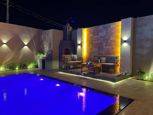 un cortile con piscina di notte di The Palms Resort (3) a Riyad