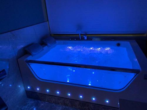 eine große blaue Badewanne mit Lichtern in einem Zimmer in der Unterkunft The Palms Resort (3) in Riad
